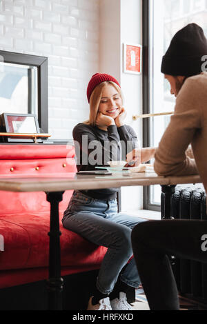 Vertikales Bild von glücklichen Paar sitzt am Tisch im Café am Tag. Mann seine Freundin Fütterung Stockfoto