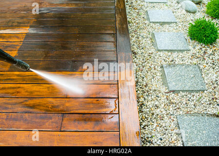 Reinigung Terrasse mit einen Hochdruckreiniger - Hochwasser Hochdruckreiniger auf Holzterrasse Oberfläche Stockfoto