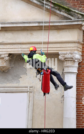 Feuerwehrmann mit Seilen klettern und Klettergeräten auf ein altes Gebäude auf die Überprüfung der Stabilität nach Erdbeben Stockfoto