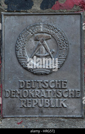 Wappen der Deutschen Demokratischen Republik auf dem Staat Grenze Schild neben dem Eingang zur Mauermuseum (Mauermuseum) in Berlin, Deutschland angezeigt. Stockfoto