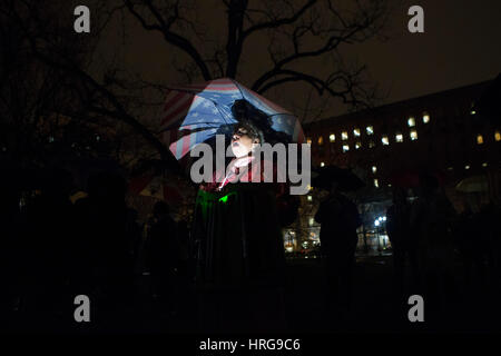 Carla Sachs hält ein Protest-Zeichen und eine amerikanische Flagge Regenschirm in Lafayette Park gegenüber dem weißen Haus während der Widerstand Adresse Rallye auf Dienstag, 28. Februar 2017 in Washington, D.C. Stockfoto