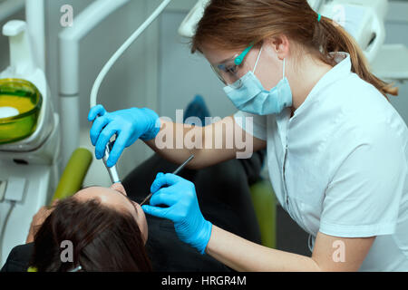 Patientin beim Zahnarzt Bohren den Zahn mit einer Turbine und Herstellung Zahnfüllungen Stockfoto