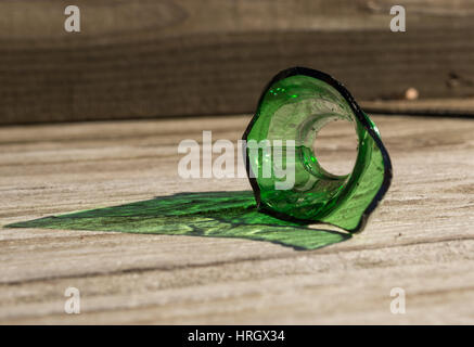 Gebrochene grüne Glasflasche mit Holz Hintergrund. Stockfoto