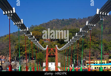 Indien Uttarakhand Zustand Rishikesh die Welthauptstadt des Yoga an den Ufern des Flusses Ganga Ram Jhula Brücke im blauen Himmel Stockfoto