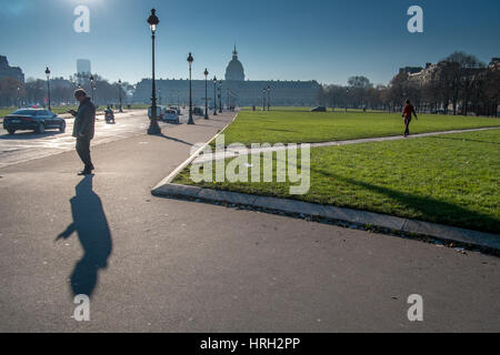 Person Überprüfung Telefon wirft lange Winter Schatten mit Les Invalides im Hintergrund, Paris, Frankreich. Stockfoto