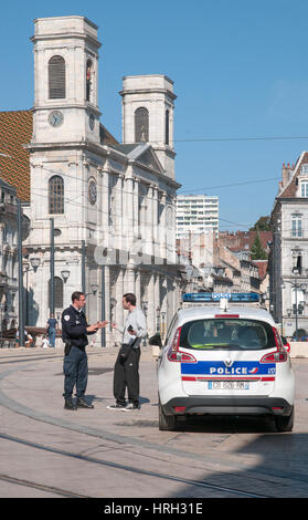 Junger Mann mit Auseinandersetzung mit Polizist im Ort Claude Francois Jouffroy in der Nähe von Pont Battant Besancon Frankreich mit Kirche Eglise Sainte Madeleine de Stockfoto