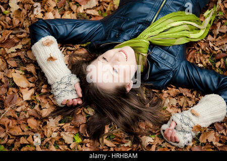 Model Release, Frau Liegt Wohnhauses Im Herbstlaub - Frau entspannend im Herbstlaub Stockfoto