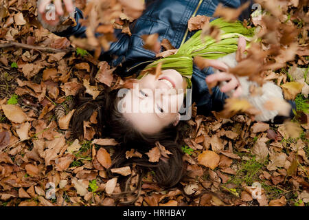 Model Release, Frau Liegt Wohnhauses Im Herbstlaub - Frau entspannend im Herbstlaub Stockfoto