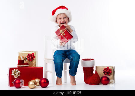 Model Release, Junge Mit Weihnachtsmuetze Und Weihnachtsgeschenken - Weihnachten-Boy Stockfoto