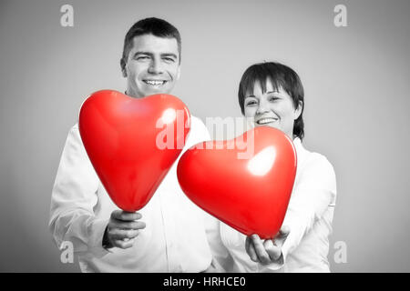Paar Mit Herzluftballonen - paar mit Herz Luftballons Stockfoto