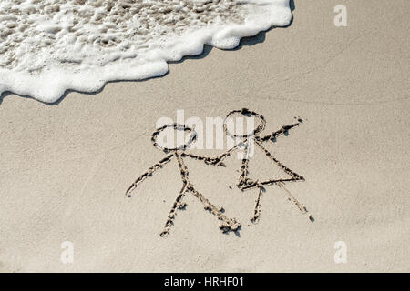 Paar Im Sandstrand - paar am Strand, symbolisch für Stockfoto