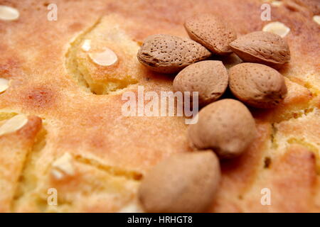 Ungeschälte Mandeln Nüssen auf einem frisch gesicherten Frangipane-Torte oder Kuchen Stockfoto