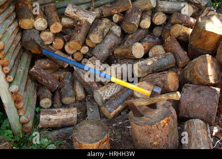 Holzstapel mit Äxten und Hackstock Stockfoto