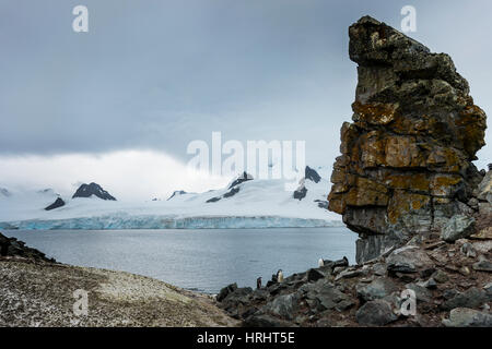 Pinguine unter dramatischen rock-Formationen, Half Moon Bay, Süd-Sheltand-Inseln, Antarktis, Polarregionen Stockfoto