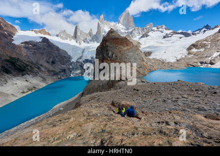 Ein paar in Bergausrüstung ruht auf den Felsen mit Blick auf Lago de Los Tres und Mount Fitz Roy, Patagonien, Argentinien Stockfoto