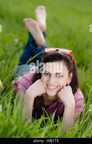 Junge Frau Liegt in der Fruehlingswiese - junge Frau auf der Frühlingswiese Stockfoto