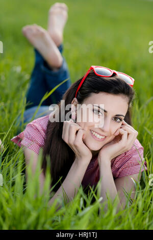 Junge Frau Liegt in der Fruehlingswiese - junge Frau auf der Frühlingswiese Stockfoto