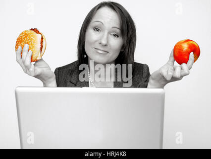 Burger Oder Apfel als Jause w? Hrend der Arbeitszeit - Burger oder Apple auf dem Arbeitsmarkt, Symbolfotos Stockfoto