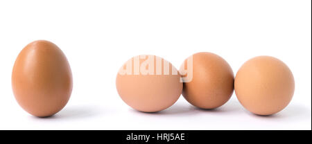 Große braune Hühner-Ei und eine Gruppe von drei Eiern isoliert auf weiss. Stockfoto