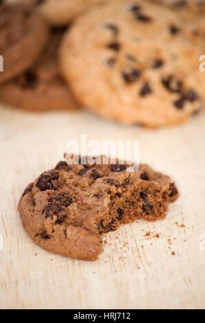 die Hälfte gegessen Schoko-Cookie auf Holzplatte Stockfoto