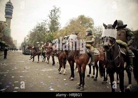 Eine Linie der chilenischen berittene Polizei beobachten Demonstranten eine Demonstration in der Innenstadt von Santiago, Chile. Stockfoto