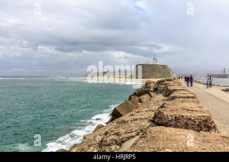 Bulk-Carrier Eintritt in Newcastle Hafen von Nobbys Head Beach und Wellenbrecher, New South Wales, Australien Stockfoto