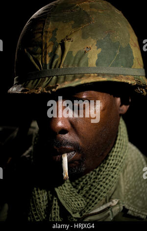 Porträt des afroamerikanischen Soldaten aus der Zeit des Vietnam-Krieges vor einem schwarzen Hintergrund. Dunkle Schatten für ein dramatischer Bild verwendet. Stockfoto