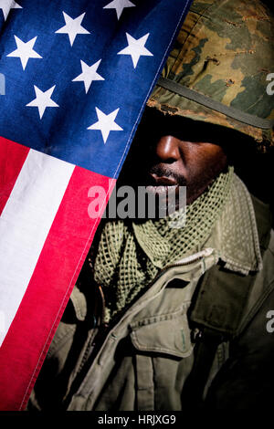 Porträt des afroamerikanischen Soldaten aus der Zeit des Vietnam-Krieges vor einem schwarzen Hintergrund. Dunkle Schatten für ein dramatischer Bild verwendet. Stockfoto