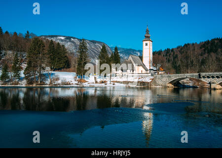 Kirche St. Johannes der Täufer und alten Stein in Bohinj während der Wintersaison zu überbrücken Stockfoto