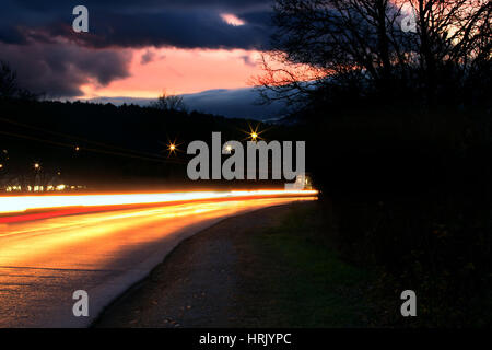 Langzeitbelichtung Foto des Verkehrs auf den Umzug in der Abenddämmerung Stockfoto