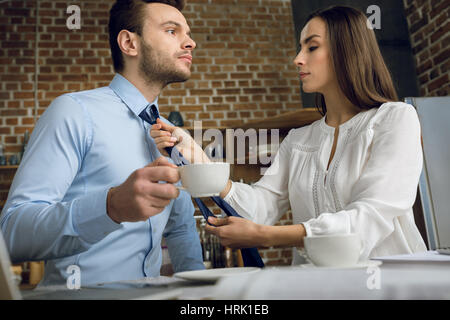 niedrigen Winkel Ansicht der Geschäftsfrau Mannes Krawatte zu binden, in Küche Stockfoto