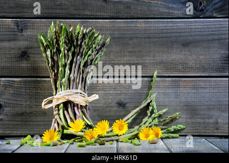 Nahaufnahme der leckere Natur- und vitaminreiche frische Spargel frisch gepflückt auf dem Lande, fotografiert auf einem alten Holztisch. Stockfoto