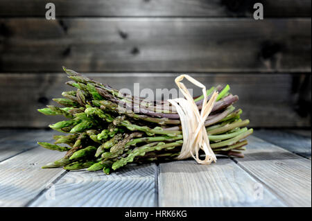 Nahaufnahme der leckere Natur- und vitaminreiche frische Spargel frisch gepflückt auf dem Lande, fotografiert auf einem alten Holztisch. Stockfoto