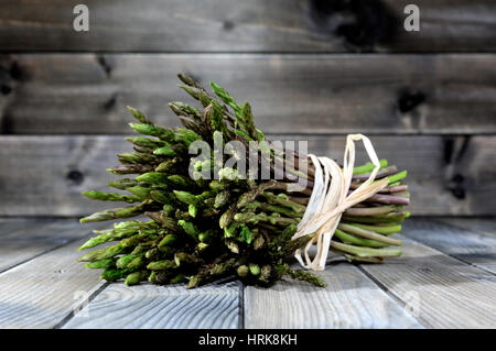 Nahaufnahme der leckere Natur- und vitaminreiche frische Spargel frisch gepflückt auf dem Lande, fotografiert auf einem alten Holztisch. Stockfoto