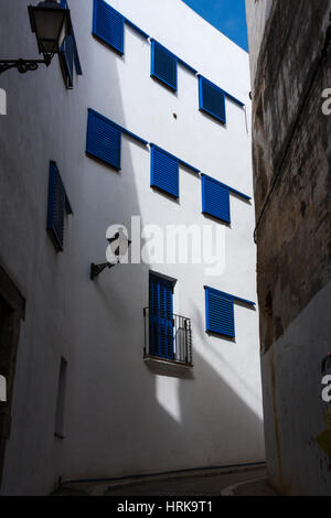 Sonnenlicht auf blauen Fensterläden in engen Gassen in der Altstadt von Sitges, Katalonien, Spanien, Europa Stockfoto