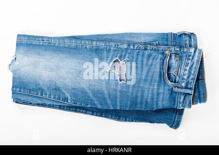 Zerrissene Jeans blau auf weißem Hintergrund gefaltet. Ansicht von oben. Modekonzept. Stockfoto