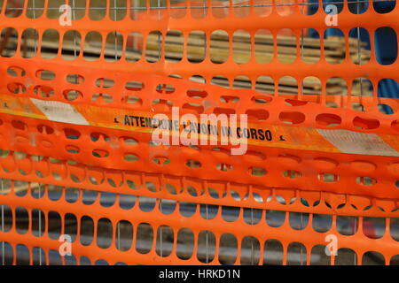 Kunststoff orange Sicherheitsnetz zum begrenzen von Bereich einer Straßenbaustelle mit italienischen Worte Bedeutung Vorsicht WORK IN PROGRESS Stockfoto