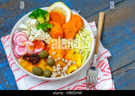 Vegane Buddha Schüssel - Zucchini Nudeln, Süßkartoffeln, Tofu mit Gemüse. Liebe für eine gesunde vegane Ernährung Konzept Stockfoto