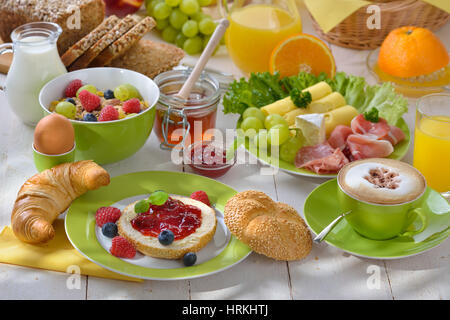 Im Freien serviert Frühstück mit einer Tasse Cappuccino und eine große Auswahl an Speisen Stockfoto