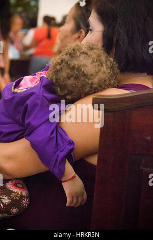 Venezuela Caracas 26/03/2013. Mutter mit ihrem Baby in der Kirche Ostern feiern. Stockfoto