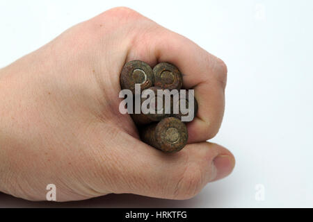 Hand hält die alten Patronen auf einem weißen Hintergrund. Stockfoto