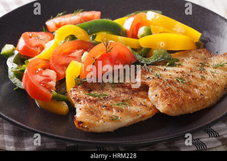 Gegrillte Tilapia Filets und frische Paprika und Tomaten auf einer Platte Nahaufnahme. horizontale Stockfoto