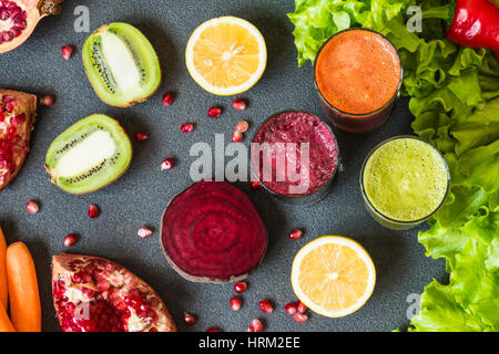 drei Gläser von verschiedenen frischen Saft. Rüben, Karotten und Kiwi Säfte auf grauem Hintergrund. Stockfoto