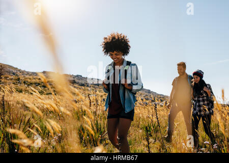 Gruppe von Personen in Landschaft wandern. Junge Frauen und Männer auf Bergtour. Stockfoto