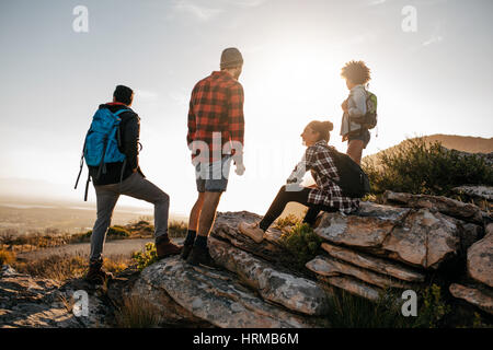 Gruppe von Wanderern auf Hügel und die Aussicht genießen. Junge Menschen wandern in der Natur. Stockfoto