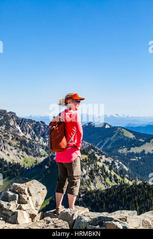 Eine Frau Wanderer auf Dege Peak, Mount Rainier National Park, Washington, USA. Mount Stuart können in der Ferne gesehen werden. Stockfoto
