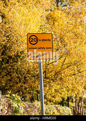 Wegweiser zeigen 20 MPH Höchstgeschwindigkeit 20 sagen viele, dass Schule Sicherheitszone gegen Herbst Bäume Stockfoto