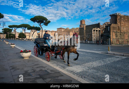 Pferd und Kutsche scheppert entlang einer leeren Via dei Fori Imperiali, Rom, Italien Stockfoto
