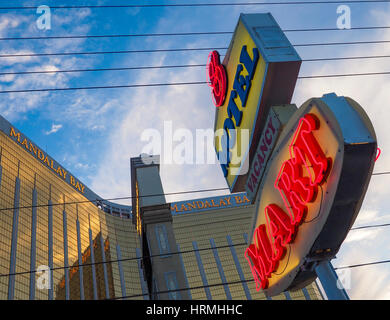 Die beleuchtete Leuchtreklame der ein Budget Motel vor der Fassade des Mandalay Bay-Luxus-Hotel und Casino auf dem Las Vegas Strip. Stockfoto