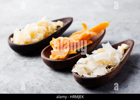 Gesunde Snacks. Getrocknete Mango, Kokos-Chips und Palmzucker in Holzschalen. Grauen Stein Hintergrund. Textfreiraum Stockfoto